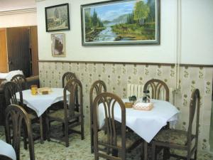 a dining room with two tables and chairs and a painting at Hotel La Parra in Archena