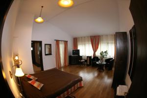 a bedroom with a bed and a living room at Timis Valley, Casa Eni&Dan in Predeal