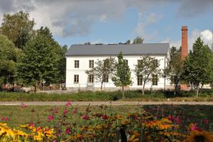 een wit huis met bloemen ervoor bij Hotelli Kartanon Meijeri in Mäntsälä