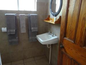 a bathroom with a sink and a mirror at La Paix Guesthouse in Beaufort West