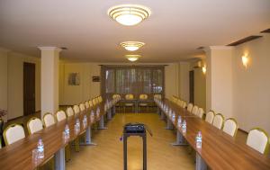 una sala de conferencias con una mesa larga y sillas en Hotel Beaumonde Garden en Tiflis