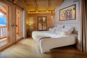 a bedroom with a large white bed in a room at Chalet Stellaone - OVO Network in La Clusaz
