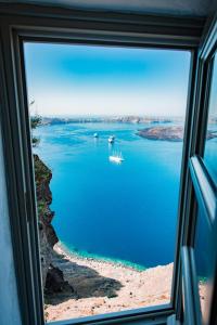 a view of the water from a train window at Iconic Santorini, a Boutique Cave Hotel in Imerovigli