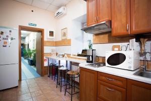 a kitchen with wooden cabinets and a white microwave at Guest House Ligovsky in Saint Petersburg