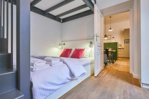 sypialnia z łóżkiem z białą pościelą i czerwonymi poduszkami w obiekcie Kurkowa GamaHome Cozy Apartments w Krakowie