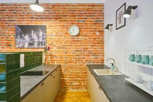 kuchnia z ceglaną ścianą i zegarem na ścianie w obiekcie Kurkowa GamaHome Cozy Apartments w Krakowie +37 zdjęć