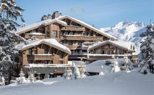 un lodge de esquí en la nieve con árboles nevados en Hôtel Barrière Les Neiges Courchevel en Courchevel