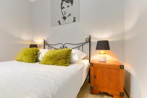 a bedroom with a bed and a night stand with a lamp at Apartament Bursztynowy Rezydencja Park in Mielno