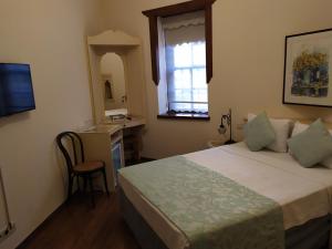 1 dormitorio con cama, escritorio y ventana en Minyon Hotel, en Antalya