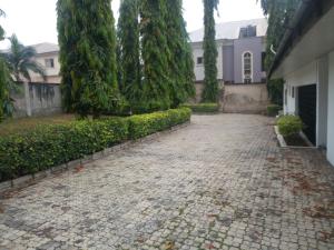 a stone driveway in front of a house with trees at Tiffany Apartments in Ibadan