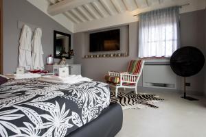 a bedroom with a black and white bed and a chair at BellaVista di Mammi in Castiglion Fiorentino