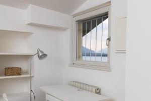 a white kitchen with a window and a desk at Casa Piazza Del Porto in Lovere