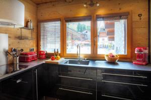 a kitchen with a sink and a window at Chalet Artedaz - OVO Network in La Clusaz