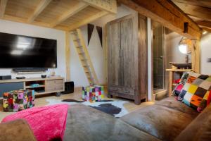 a living room with a couch and a flat screen tv at Chalet Artedaz - OVO Network in La Clusaz