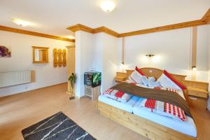 a bedroom with a large bed with red and white pillows at Landgasthof Penn in Windorf
