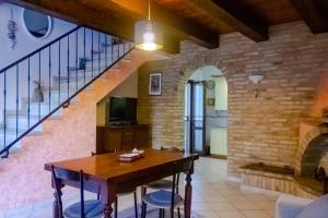 a dining room with a table and a staircase at A Casa di Claudia in Loreto