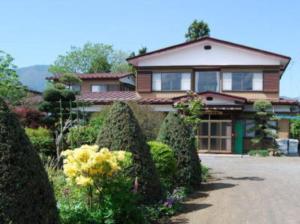 a house with a bunch of bushes in front of it at Minshuku Iwaki in Fujikawaguchiko