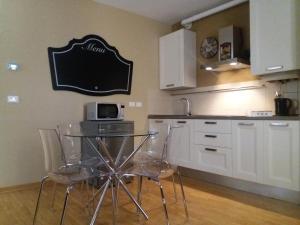 a kitchen with a table with chairs and a microwave at Suite Saragozza Free small Parking,Bologna in Bologna