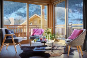 a living room with two chairs and a table in front of a window at Chalet Pajules - OVO Network in Le Fey