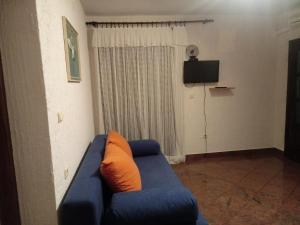 ein blaues Sofa mit orangefarbenem Kissen im Wohnzimmer in der Unterkunft Marijan apartments in Crikvenica