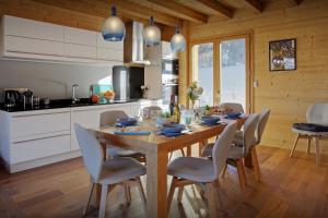 a kitchen with a wooden table with chairs around it at Chalet Pajules - OVO Network in Le Fey