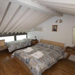ローヴェレにあるNido del Tadiniのベッドルーム(ベッド2台付)が備わる屋根裏部屋です。