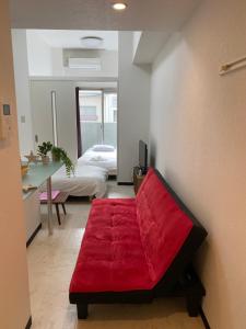 a red couch in a room with a bedroom at Lion Tsurumi in Hiroshima