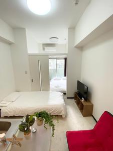 - une chambre avec un lit, une télévision et un canapé dans l'établissement Lion Tsurumi, à Hiroshima