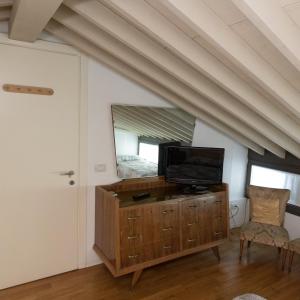 Habitación con TV en un tocador con espejo en Nido del Tadini, en Lovere
