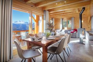a dining room with a wooden table and chairs at Chalet Tekoa - OVO Network in Manigod