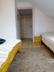 um quarto com duas camas e uma porta em Roztoczański Dworek em Zamość