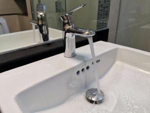 a sink with a faucet with water in it at Escape Condominum E125 in Mae Pim