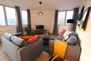 a living room with two couches and a table at Colmar City Center - Bright and Large Appartement REMPARTS in Colmar
