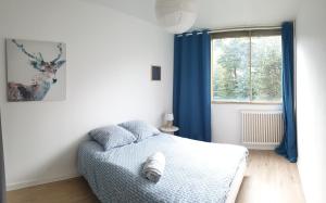 1 dormitorio con 1 cama y una ventana con cortinas azules en Le Regent City of Design, en Saint-Étienne