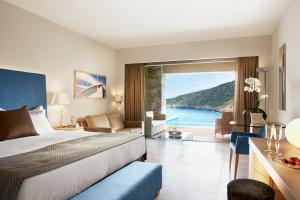 a hotel room with a bed and a view of the ocean at Daios Cove in Agios Nikolaos