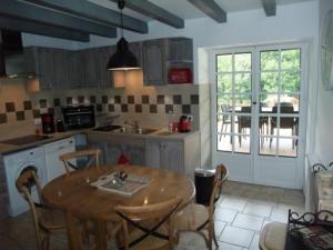 a kitchen with a wooden table and a table and chairs at Le Domaine du Grand Cellier Chambres d'hôtes en Savoie in Tournon