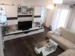 a living room with a couch and a tv at Apartman Lana in Šilo