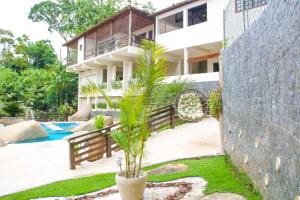 a house with a palm tree in front of a building at Casa Pedra Bonita in Rio de Janeiro