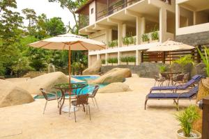 a patio with chairs and a table with an umbrella at Casa Pedra Bonita in Rio de Janeiro