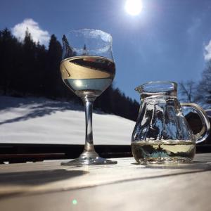 a glass of wine next to a jar of water at Appartement Schuricht in Reit im Winkl