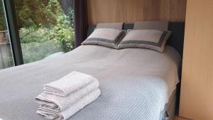 a bed with towels on it with a window at Mirror House Roosi 21 in Pärnu