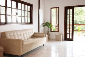 a living room with a white couch and windows at Casa Pedra Bonita in Rio de Janeiro