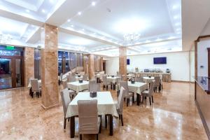 a restaurant with tables and chairs in a room at Ambassador Hotel in Chişinău
