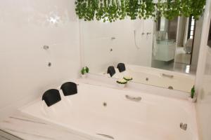 a white bath tub with two black chairs in a bathroom at Casa Pedra Bonita in Rio de Janeiro