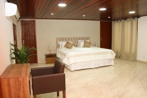 a bedroom with a bed and a chair in it at Casa Pedra Bonita in Rio de Janeiro