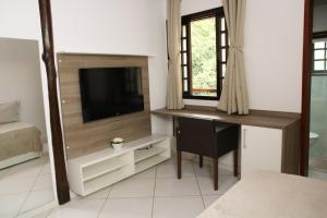 a bedroom with a desk and a television in a room at Casa Pedra Bonita in Rio de Janeiro