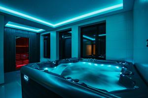 a bathroom with a black tub with blue lighting at Mountain Paradise & Wellness in Izvoare