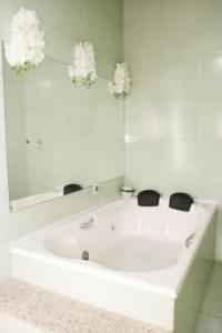 a white bath tub in a bathroom with a mirror at Casa Pedra Bonita in Rio de Janeiro