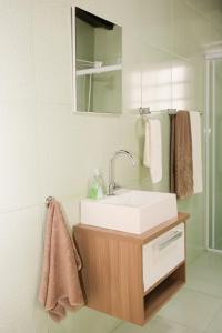 a bathroom with a sink and a mirror and towels at Casa Pedra Bonita in Rio de Janeiro