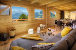a living room with a couch and tables and windows at Chalet Marinaka - OVO Network in Manigod